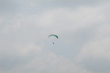 One parachute of paragliding on cloudy sky background