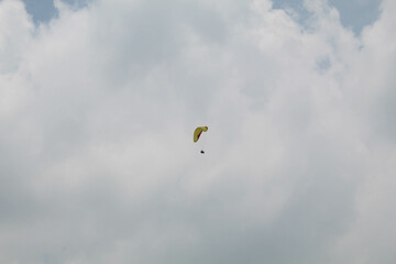 One parachute of paragliding on cloudy sky background