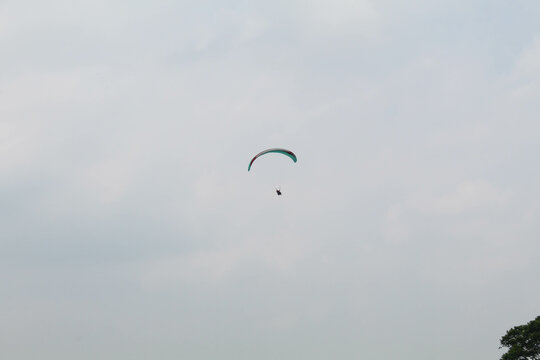 One parachute of paragliding on cloudy sky background