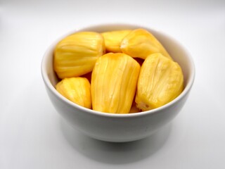 Golden-yellow flesh of ripe jackfruit on a white bowl isolated on a white background. Sweet and delicious of flesh jackfruit