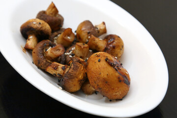 Fried champignons on a white oval plate.