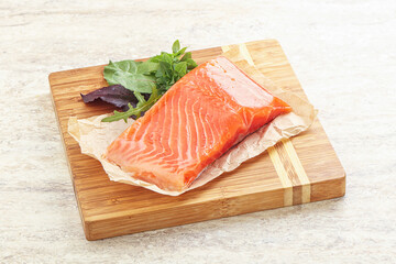 Raw salmon fillet over board