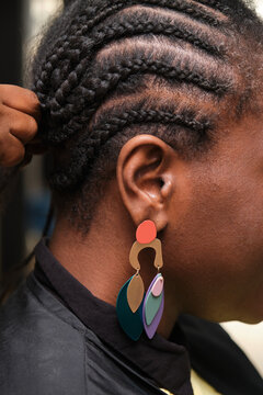 Hairdresser braiding crochet braids to black woman in salon