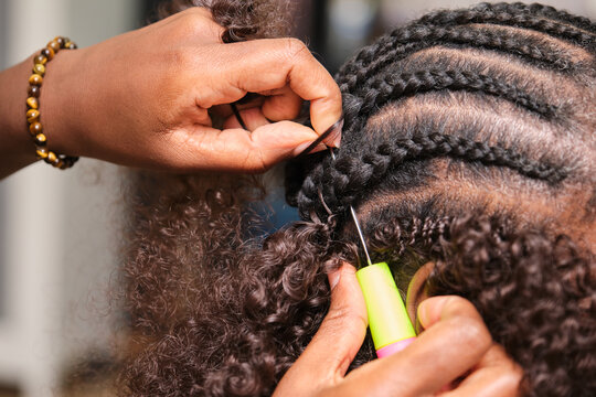 Hairdresser making crochet braids hairstyle in afro hair salon