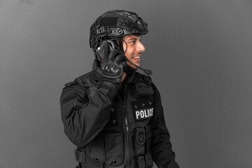 SWAT caucasian man isolated on grey background keeping a conversation with the mobile phone with someone