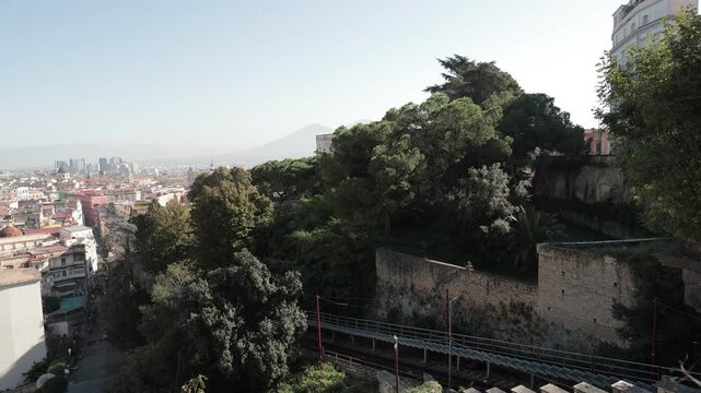 Funicular riding from the lower part of the napoli city towards the saint elmo fortress above the ground. Visible panorama of the napoli city with the white and blue funicular