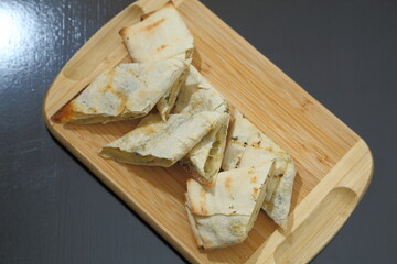 Lavash with baked cheese. Lavash with baked cheese on a wooden board. Lavash with cheese.