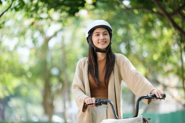 Obraz premium A woman wearing a helmet is riding a bicycle