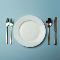Empty white plate with silverware neatly arranged on a blue background, showing a minimalistic setting.