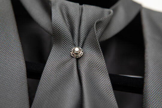 Elegant gray cravat with diamond brooch on a mannequin