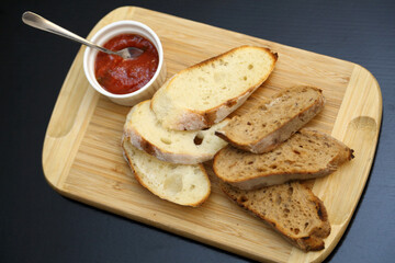 Toasted black and white bread with special sauce. Crispy toasts. Crispy toasts with sauce on a wooden board.