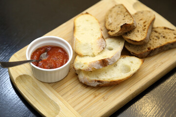 Toasted black and white bread with special sauce. Crispy toasts. Crispy toasts with sauce on a wooden board.
