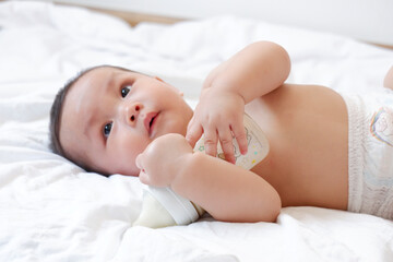 Little boy playing on white bed. Toddler concept.