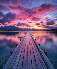 Obraz premium Serene sunset over a wooden pier stretching into a tranquil lake