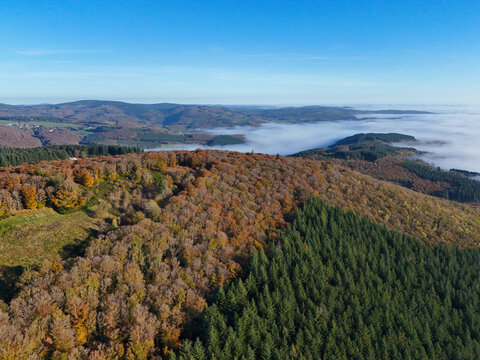 Aerial view of Mont Beuvray in the Morvan in Burgundy, France, with the forest in autumn colours and clouds in the valleys