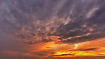 Obraz premium Dramatic sunset sky with bright orange and purple clouds above the horizon