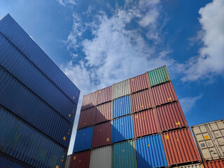 stacked shipping containers high in a busy shipping port, ready for export