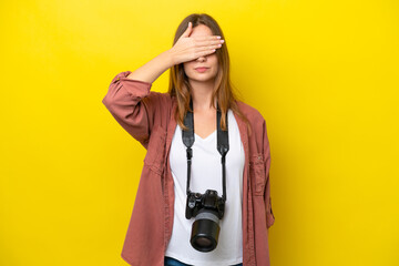 Young photographer caucasian woman isolated on yellow background covering eyes by hands. Do not...