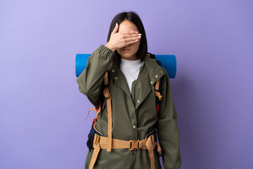 Young mountaineer woman with a big backpack over isolated background covering eyes by hands. Do not want to see something