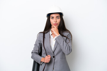 Young architect caucasian woman with helmet and holding blueprints isolated on white background thinking