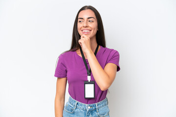 Young caucasian woman with ID card isolated on white background looking to the side and smiling