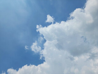 View of the sky with huge clouds covering half of the sky. Bright summer sky. View of beautiful white cumulus clouds. Monsoon Clouds Formation.
