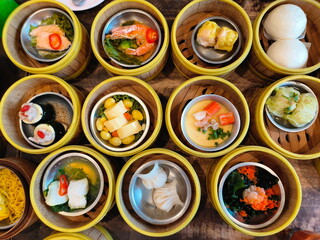 Traditional Dimsum food served in a bamboo basket. Variety of dim sum. Bamboo tray for steamed food.Cantonese term meaning small meals or snacks typically dimsum is eaten for breakfast or brunch.
