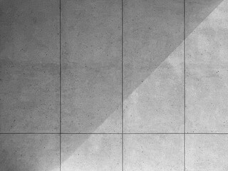 Terrazzo wall with PVC groove lines shaded by light.