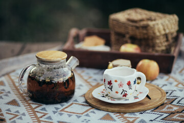 Cozy picnic with hot tea and cookies near lake.