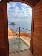Stunning view of the sea seen through an archway, with a small beach area and rocky formations in the distance