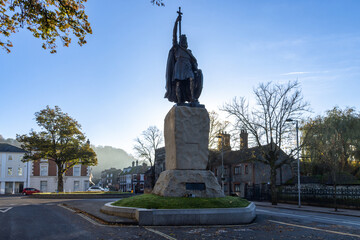 Backlit silhouette of King Alfred statue in Winchester at sunrise
