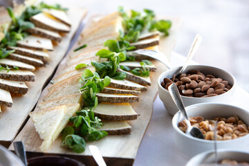 Catering cheese platter with almonds and peanuts displayed on table