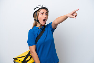Young caucasian woman with thermal backpack isolated on white background pointing away