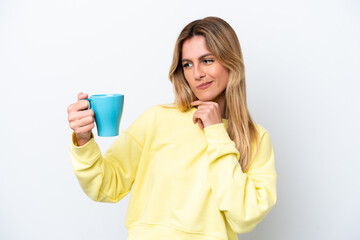 Young Uruguayan woman holding cup of coffee isolated on white background with sad expression