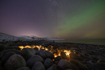 Northern lights over famous stone eggs beach in Teriberka