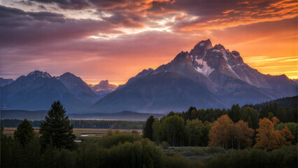Obraz premium Sunset behind mountain peaks with a dramatic mood and soft light illuminating the rich colors of the sky