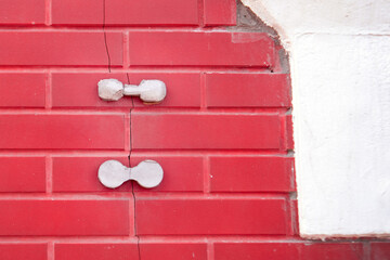 interplay of resilience and decay, showcasing concrete patches on a crack in a brick wall symbolizing attempts to mend the passage of time and structural wear
