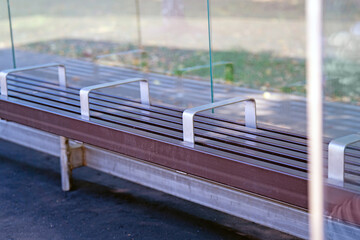 bus stop bench reinforced with metal railings serves as a stark reminder of societal boundaries,...