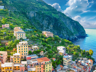 Colorful houses are built into the hillside overlooking the mediterranean sea in Cinque Terre...