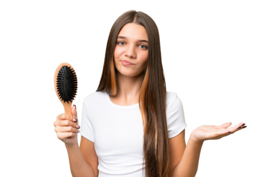 Teenager caucasian girl with hair comb over isolated background making doubts gesture while lifting the shoulders