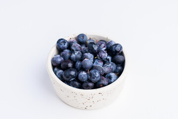 blueberries in a white bowl on a white background isolate