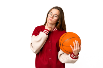 Teenager girl playing basketball over isolated chroma key background having doubts while looking up