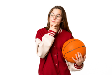 Teenager girl playing basketball over isolated chroma key background looking to the side and smiling