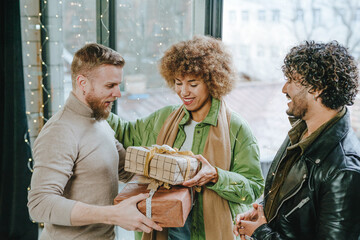 A multi ethnic group of friends giving each other a craft paper wrapped gifts