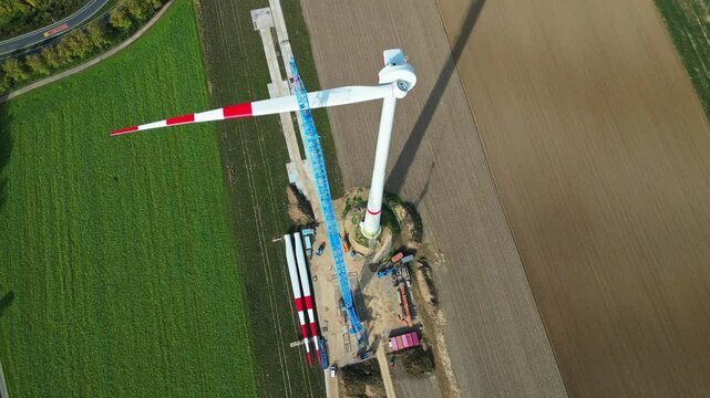 Wind power plant under construction. Aerial view of wind energy construction site on agricultural farmland.