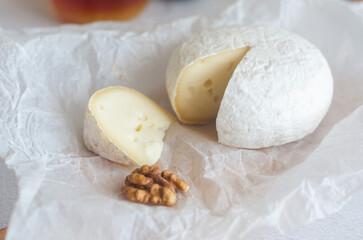 Camembert cheese with white mold, walnuts, honey and dried fruits. Dinner or aperitif concept.