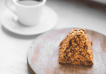 Cup of coffee and a piece of cake on a wooden board