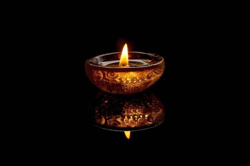 A single lit candle sits on a smooth, reflective surface, providing a warm and inviting glow
