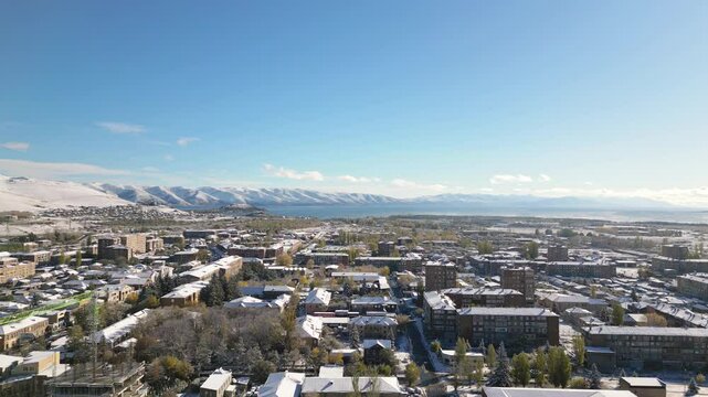 Aerial rising view Sevan town and Lake Sevan. Famous Sevan lake - large, high-altitude lake in eastern Armenia. Winter travel visit destination Armenia concept.