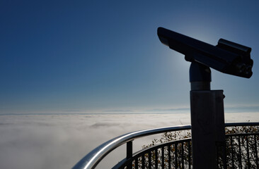 Sea of ​​fog on the Uetliberg with blue sky in autumn and telescope